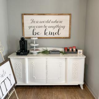A beautifully decorated console table featuring a motivational wall art piece that encourages kindness.