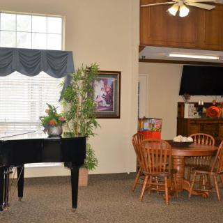 A cozy living space with a piano and dining area.