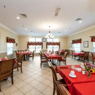 A cozy dining area with red tablecloths and neatly arranged tables and chairs.