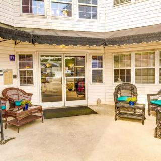 A welcoming entrance with comfortable outdoor seating and large windows.