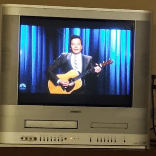 A performer singing with a guitar on a television screen.