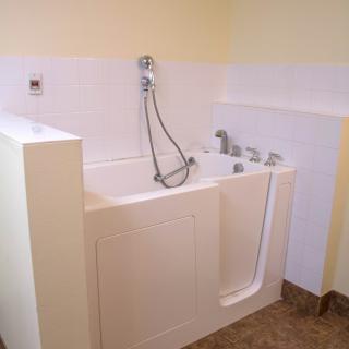 A walk-in bathtub with a shower attachment in a bathroom.