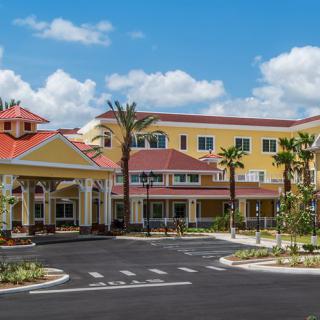 A colorful building with palm trees on a sunny day.