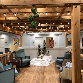 A cozy indoor lounge with holiday decorations and string lights.