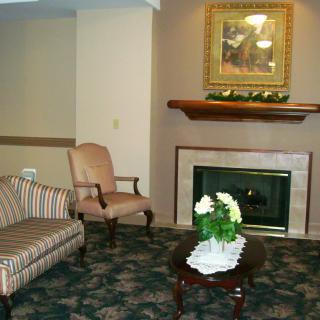 A cozy living room with a fireplace, seating, and decorative elements.