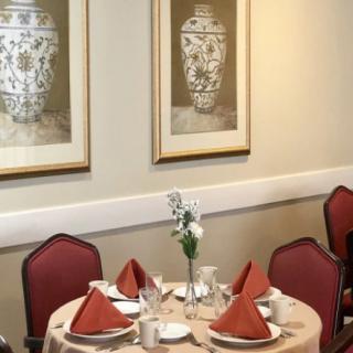 Elegant dining table setup with framed artwork in a restaurant setting.