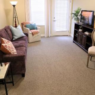 A cozy living room with a sofa, chair, television, and stylish decor.
