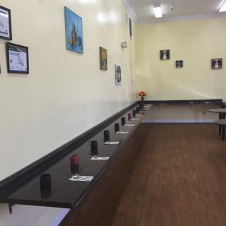 An empty internet cafe with computers lined up on desks against the wall.