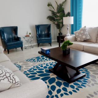A modern living room with blue and beige accents, featuring comfortable seating and stylish decor.