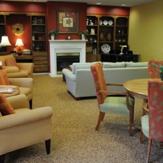 A cozy living room with a fireplace, bookshelves, and comfortable seating areas.