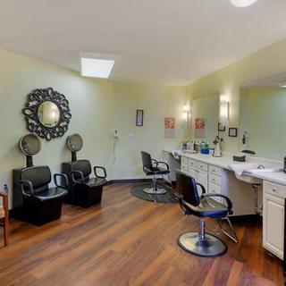 Interior view of a beauty salon with styling chairs, mirrors, and hair dryers.
