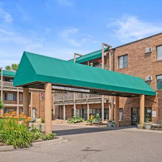 Entrance of a hotel featuring a green awning and brick architecture.