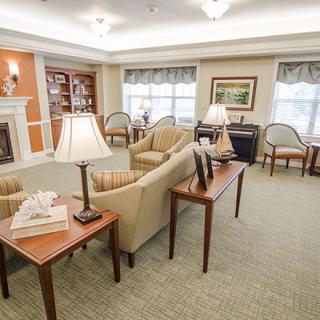 A well-lit living room with cozy seating and bookshelves.