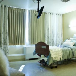 A hospital room with a medical bed and curtains drawn to block the light.