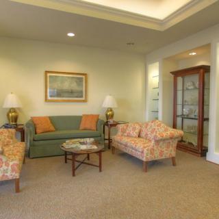 A cozy living room with sofas, armchairs, a coffee table, and decorative elements.