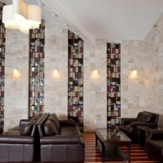 A modern lounge area with leather sofas and a unique bookshelf design.