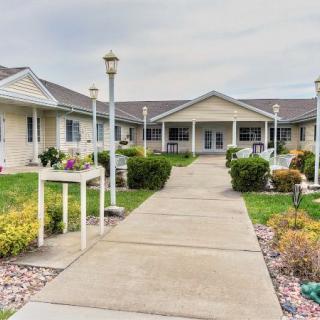 A well-maintained pathway leads to a modern residential building surrounded by landscaped gardens.