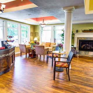 A cozy living room with a fireplace, hardwood floors, and bright natural lighting.