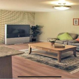 A cozy living room featuring a sofa, coffee table, and large TV.