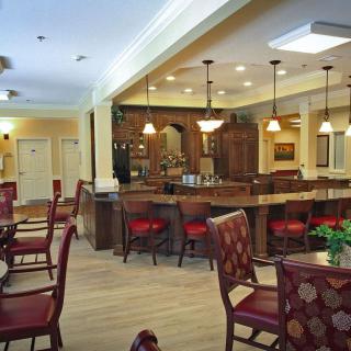A warm and inviting dining area with a bar, featuring elegant seating arrangements and ambient lighting.