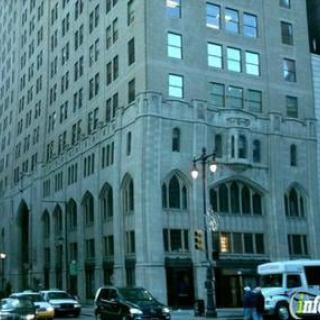 A view of a historic city building with vehicles on the street.