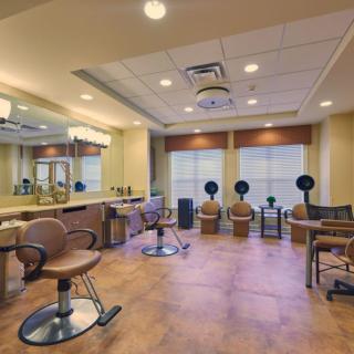 A spacious and well-lit hair salon with styling chairs and mirrors.
