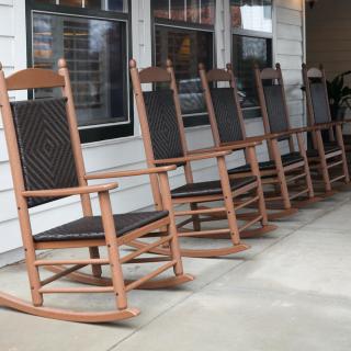 A row of wooden rocking chairs lined up on a porch.