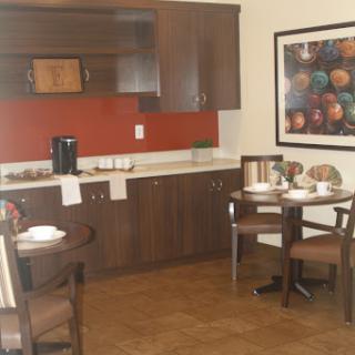A cozy kitchen and dining area featuring modern wood cabinetry and a neatly set table.
