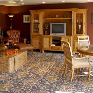 A cozy living room with wooden furniture and a patterned carpet.