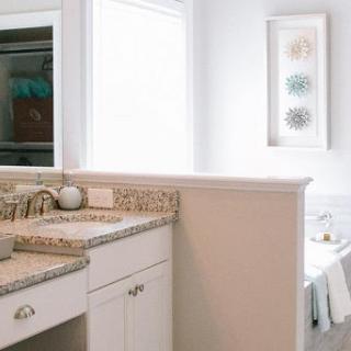 A beautifully designed bathroom featuring a modern vanity with a granite countertop and ample natural light.