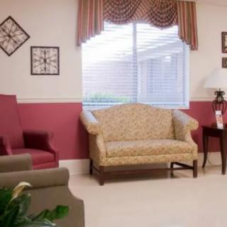 A cozy living room area with stylish furniture and a large window.