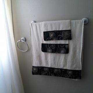 A neatly arranged towel set hanging on a wall-mounted rack in a bathroom.