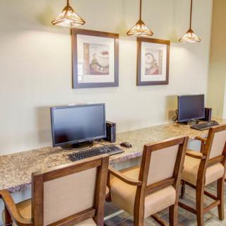 A neatly arranged computer station with chairs and desktop computers in an office setting.