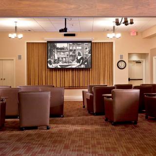 A cozy movie room with comfortable seating and a large projection screen.