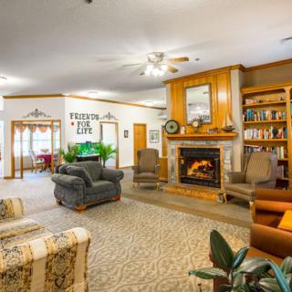 A cozy living room featuring a fireplace, comfortable seating, and a bookshelf creating a warm and inviting atmosphere.