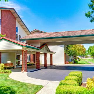 A welcoming hotel entrance with a covered driveway and well-maintained landscaping.