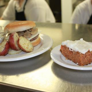 A sandwich with sliced potatoes and a piece of cake on plates.