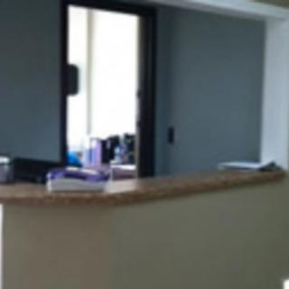 A view of an office reception desk with a window to an adjacent room.