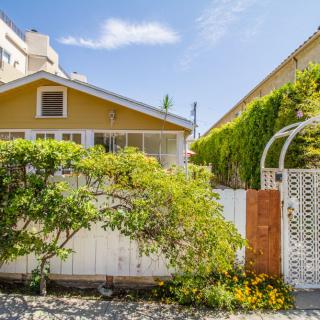 Charming house with a garden and white fence on a sunny day.