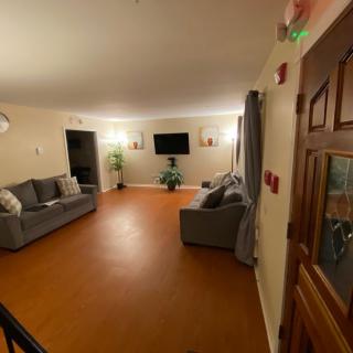 A cozy living room with sofas, a television, and warm lighting.