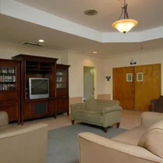 A cozy living room with comfortable seating and a classic wooden entertainment center.