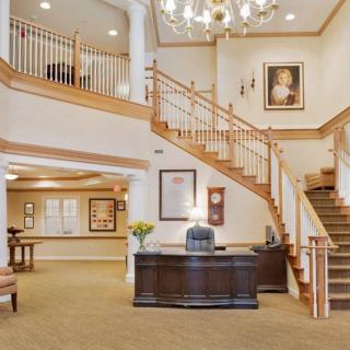 A beautifully designed lobby with a central staircase and elegant chandelier.