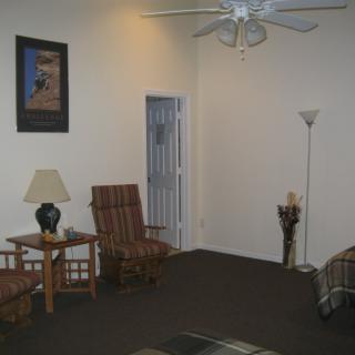 A cozy living room with a chair, table, and standing lamps.