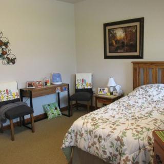 A cozy bedroom with floral bedding and decorative accents.
