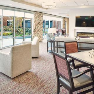 A modern and cozy living room with comfortable seating, large windows, and a fireplace.