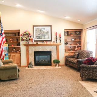 Cozy living room with a fireplace, sofas, and bookshelves.