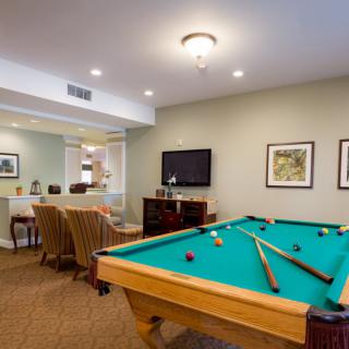 A cozy recreation room featuring a pool table, television, and comfortable seating area.