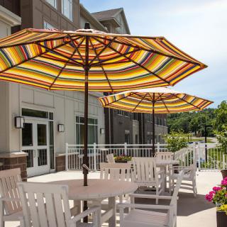 Outdoor patio area with tables, chairs, and striped umbrellas.