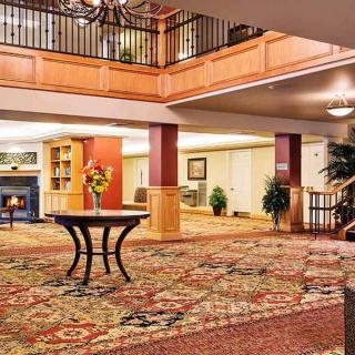 A well-decorated hotel lobby with elegant furnishings and a grand staircase.