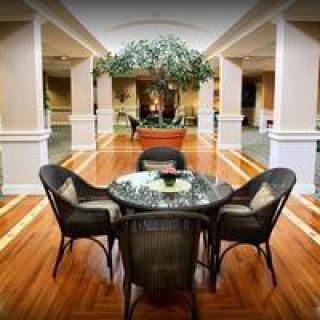 A spacious lobby area with wicker furniture and decorative plants.